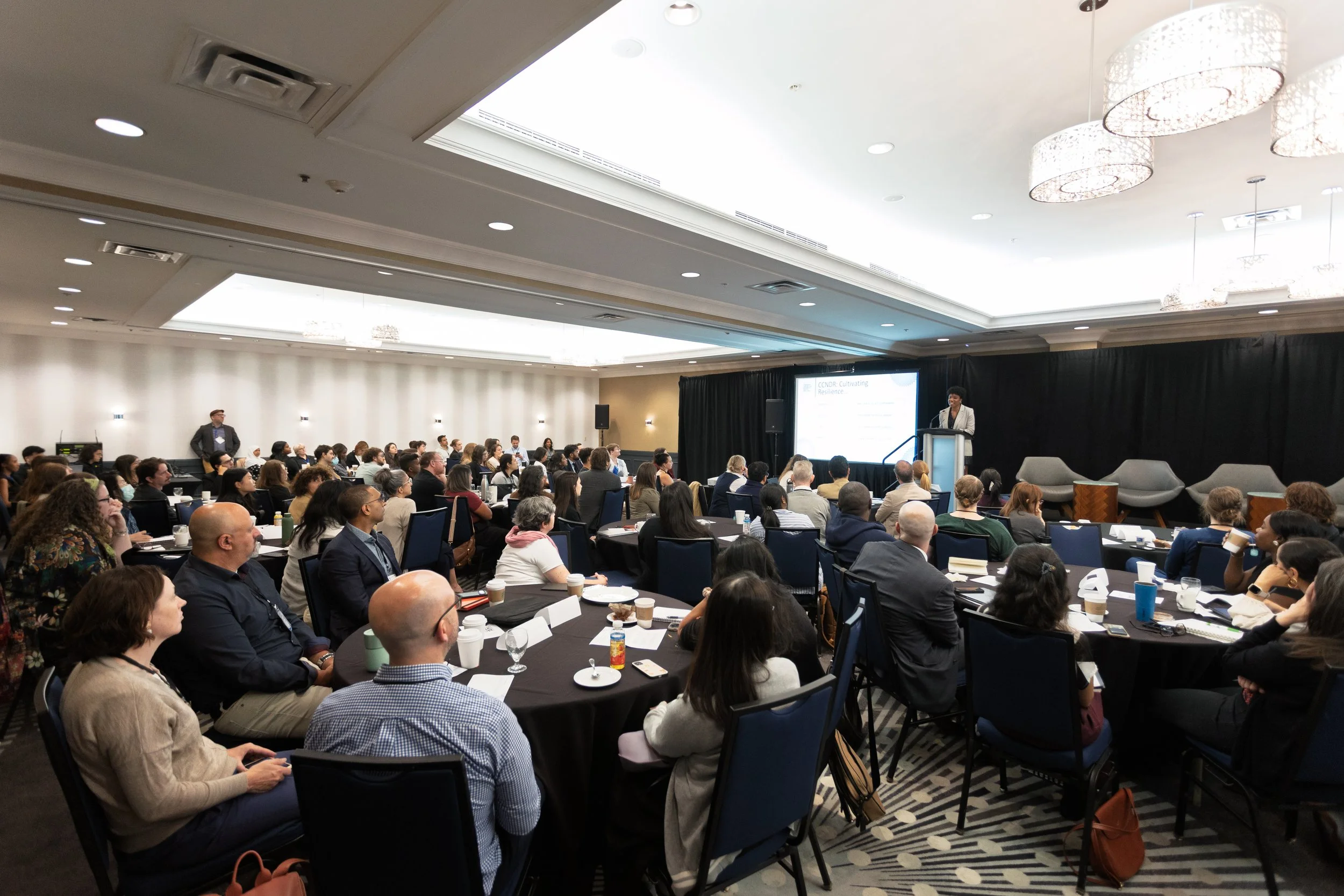 Attendees at round tables listening to a speaker at the 2025 Nonprofit Data Capacity Summit